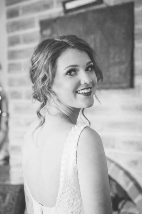 Bride smiling over her shoulder, black and white