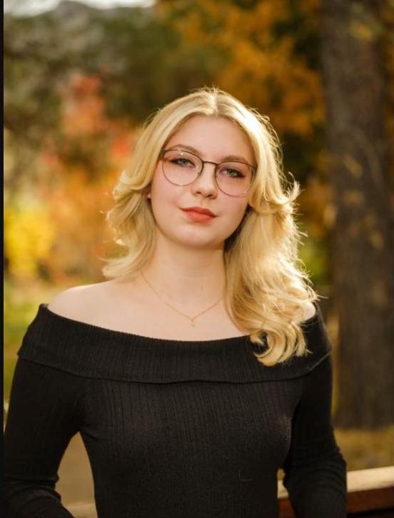 Portrait of a young woman in front of autumn leaves